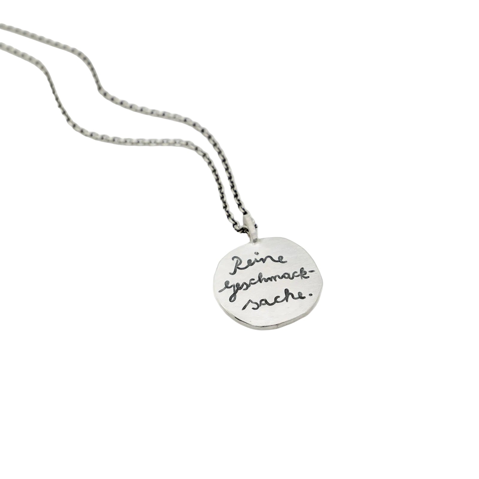 Runder, handgeschmiedeter Kettenanhänger aus Silber mit graviertem Spruch "Reine Geschmackssache".