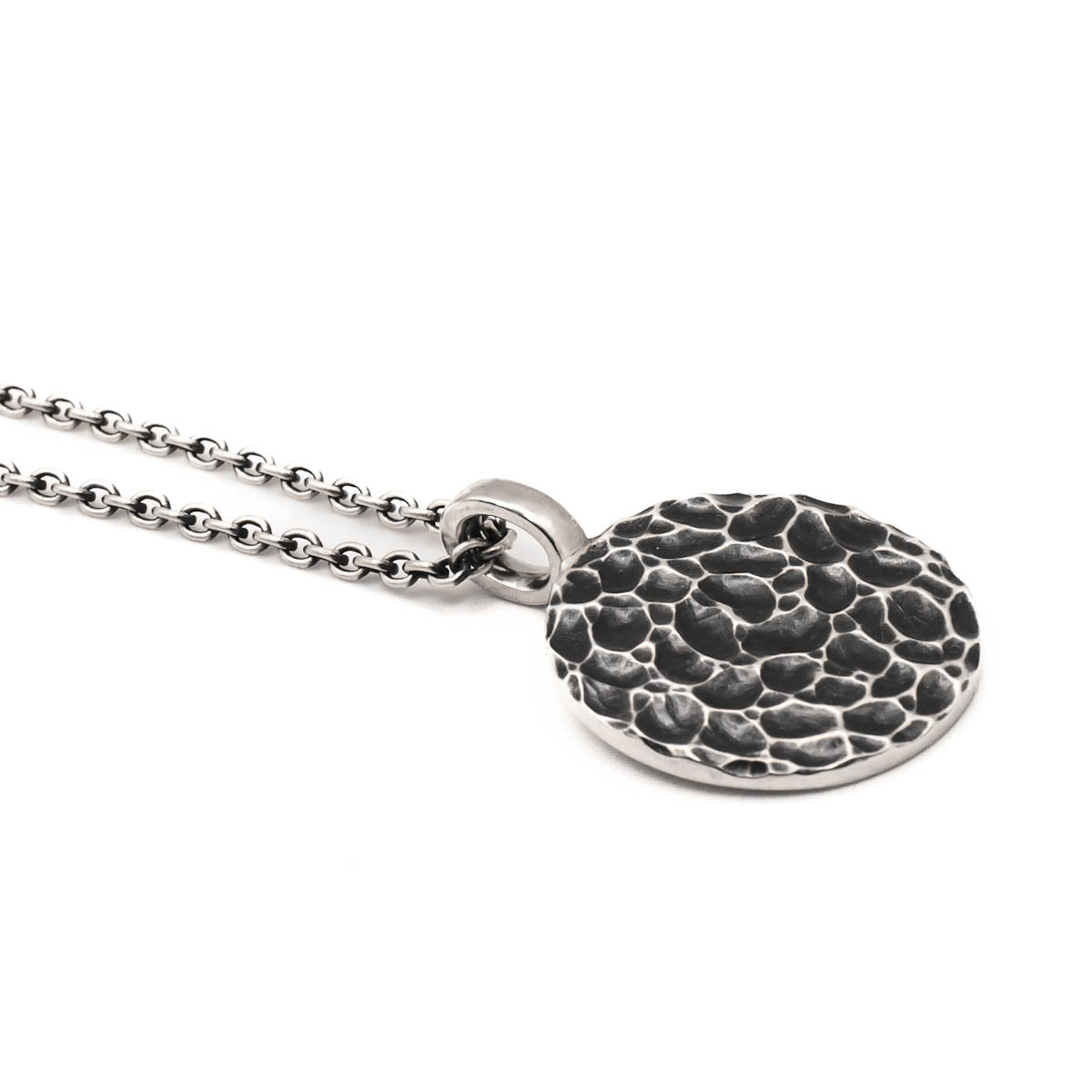 Runder massiver Anhänger aus 925 Sterling Silber mit oxidierter (geschwärzter), gefräster Oberflächenstruktur, ähnlich einer Mondlandschaft, an einer Silberkette.