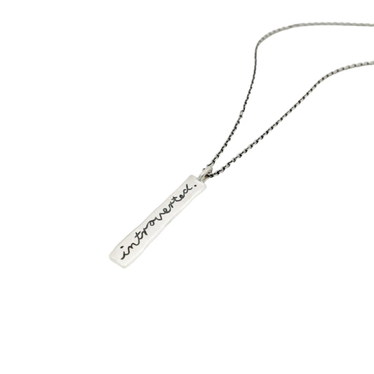 Handgeschmiedeter Anhänger aus 925 Sterling Silber mit der geschwärzten Gravur 'introverted' an einer feinen Silberkette. Statement Schmuck für Introvertierte.