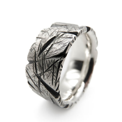 Nahaufnahme eines geschwärzten Herren-Silberrings aus 925 Sterling Silber mit grob gefeil­ter, strukturierter Oberfläche