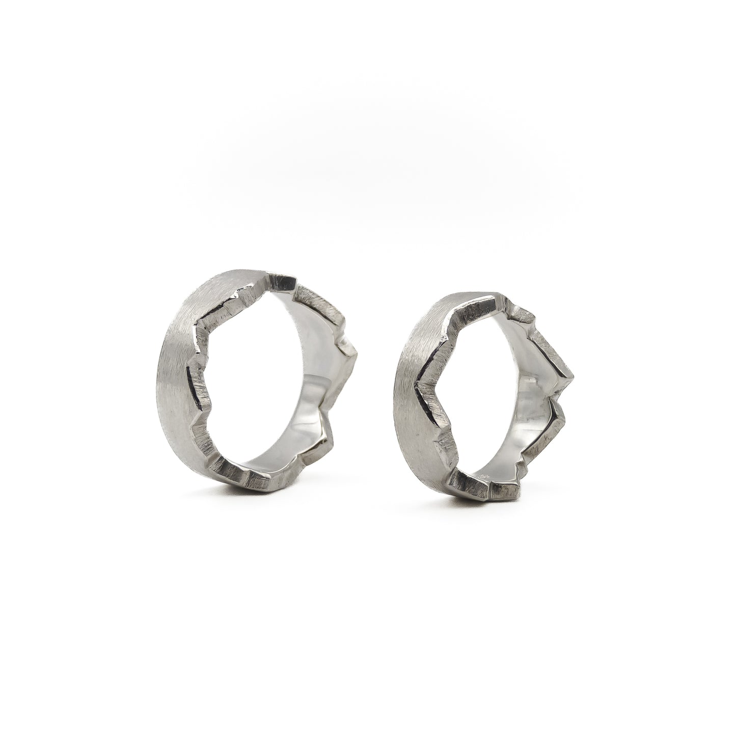 Besondere Trauringe für Paare; zwei Ringe, die durch eine selbst gezeichnete Herzlinie oder Lebenslinie zu einem perfekten Ganzen verschmelzen.