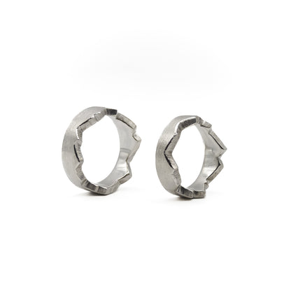 Besondere Trauringe für Paare; zwei Ringe, die durch eine selbst gezeichnete Herzlinie oder Lebenslinie zu einem perfekten Ganzen verschmelzen.